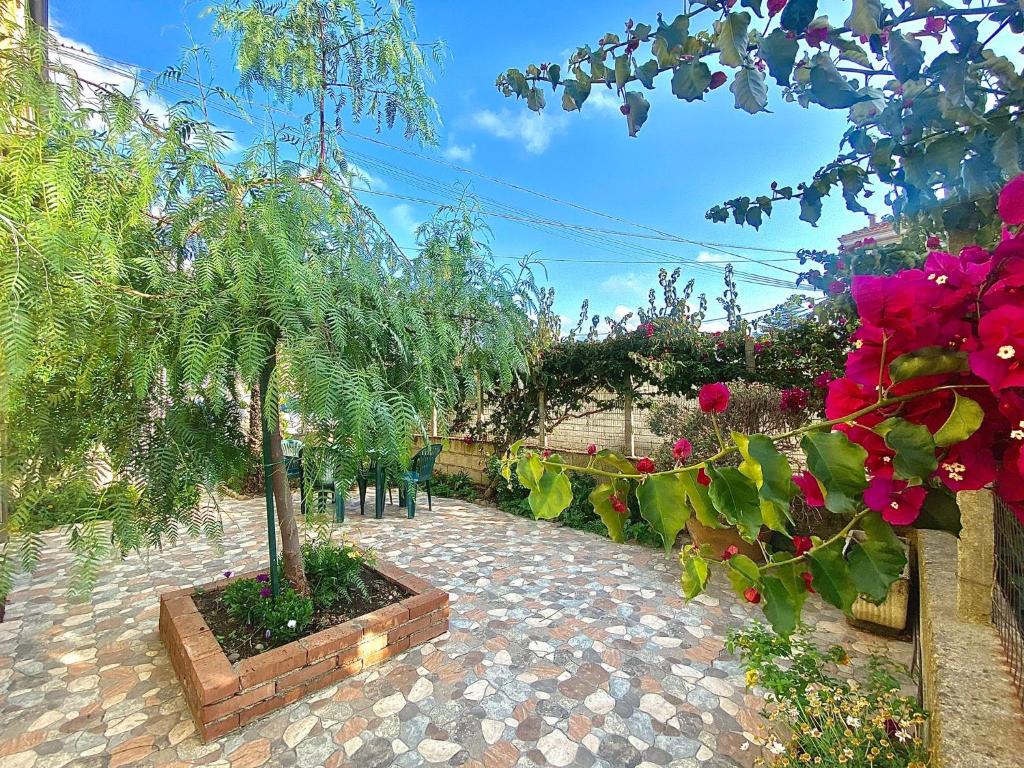 un giardino con alberi e fiori su un sentiero in mattoni di La Bouganville B&B ad Acconia