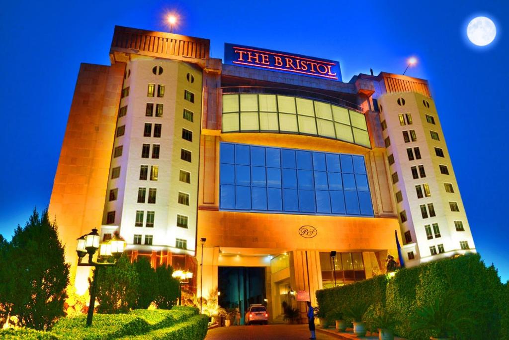 een hotelgebouw met een bord erop bij The Bristol in Gurgaon