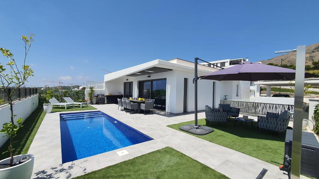 uma casa com piscina e guarda-sol em Pool & Snooker Villa em Finestrat