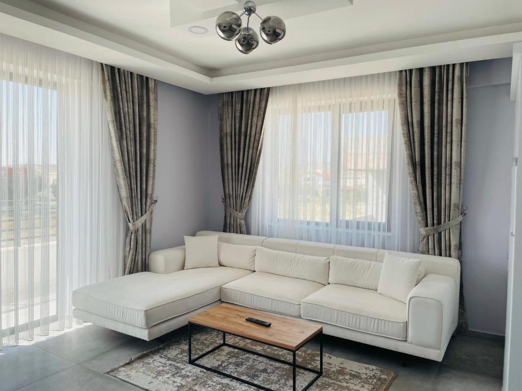 ein Wohnzimmer mit einem weißen Sofa und einem Couchtisch in der Unterkunft Apart Angel Suit 5 in Nevşehir