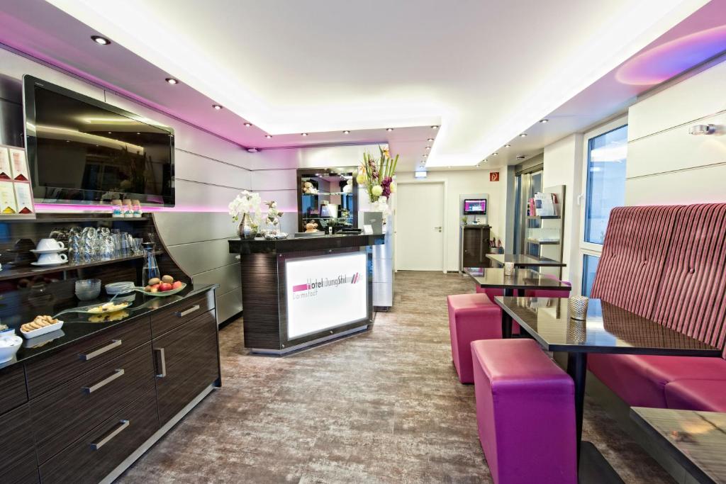 a living room with purple furniture and a flat screen tv at Hotel Jungstil in Darmstadt