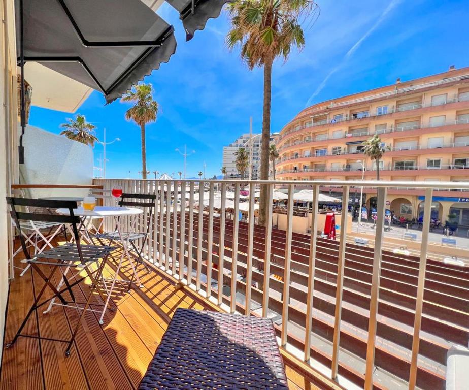 uma varanda com uma mesa e cadeiras e um edifício em Appartement vue mer Parking privé Place Med em Canet-en-Roussillon