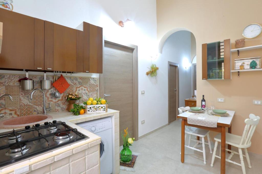 a kitchen with a stove and a table with a counter top at Casa Francesca in Avola