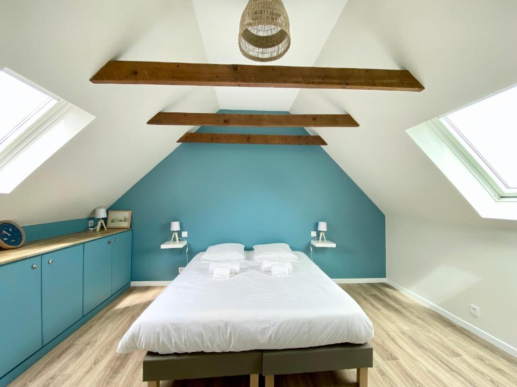 una camera da letto con un letto con pareti e finestre blu di Charmante maison au Port de Sainte Marine a Combrit