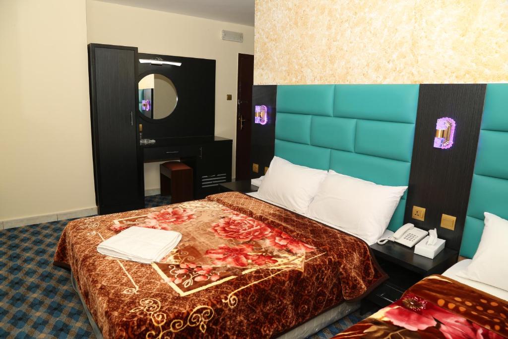 a hotel room with two beds and a mirror at Dream Square Hotel in Dubai