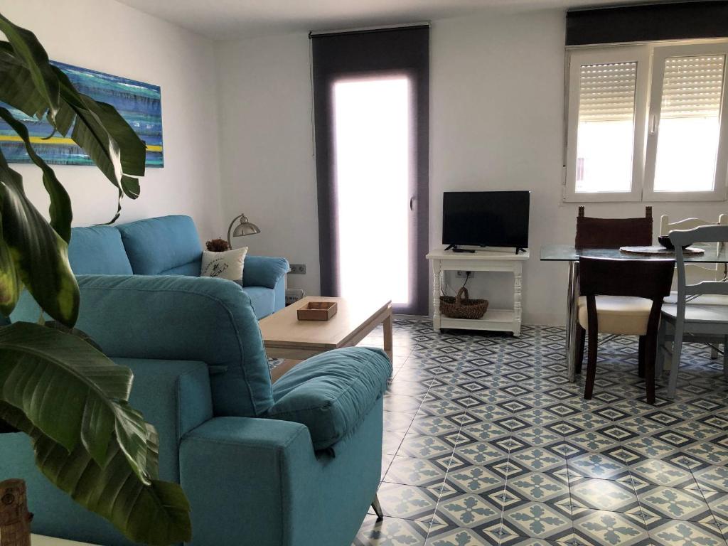 a living room with a blue couch and a table at ABA DALÍ in Conil de la Frontera