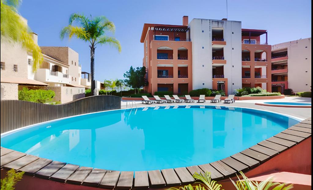 a large swimming pool in front of a building at Vilamoura Victoria Gardens With Pool by Homing in Vilamoura