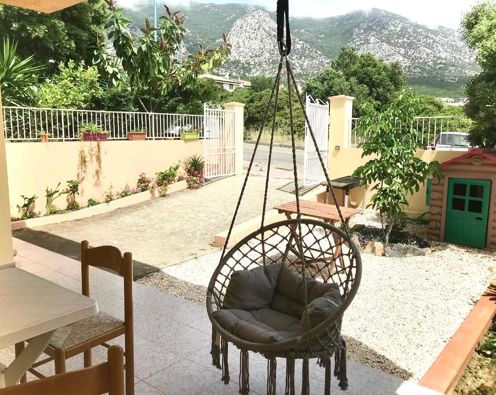 une chaise suspendue sur une terrasse couverte avec une balançoire dans l'établissement casa Alessia, à Cala Gonone