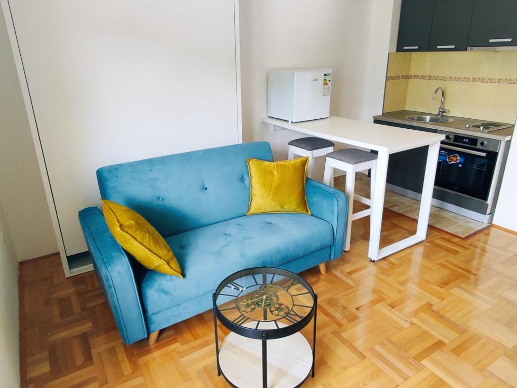 niebieską kanapę w salonie ze stołem w obiekcie Apartment Lake story w mieście Plužine