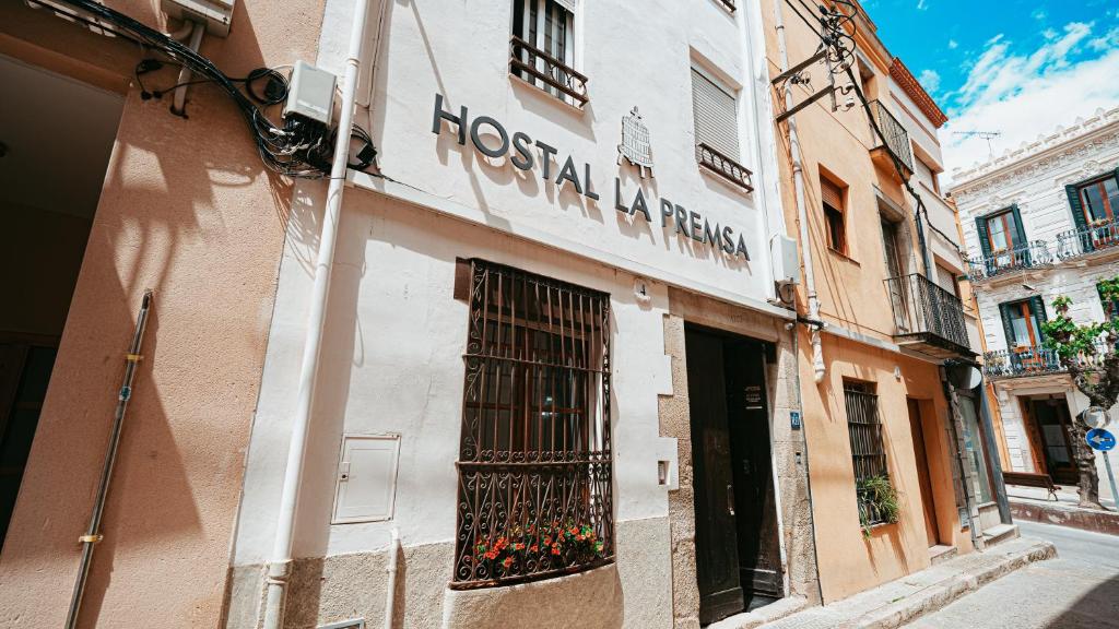 a facade of a restaurant in a street with a building at Hostal La Premsa in Arenys de Mar