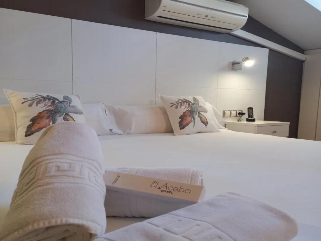 a bedroom with a white bed with a persons feet on it at Hotel El Acebo in Jaca