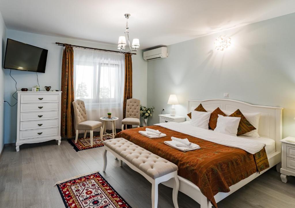 a bedroom with a large bed and a tv at Flora Luxury House in Sighişoara