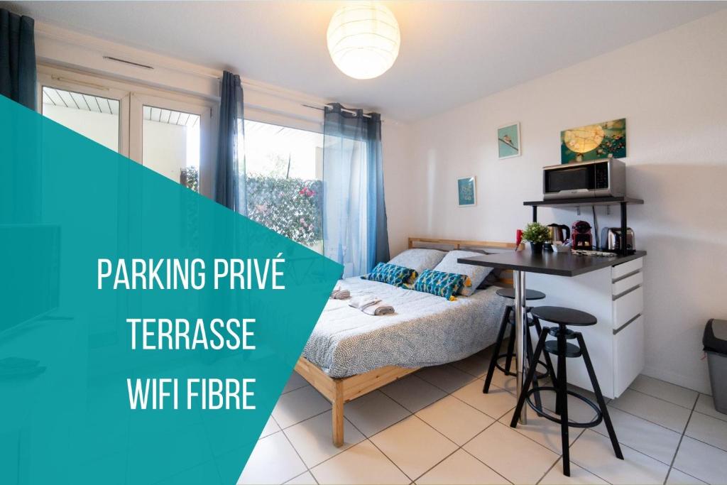 une chambre avec un lit et une table dans une pièce dans l'établissement La Terrasse St Michel - Parking -Métro - Bus, à Toulouse