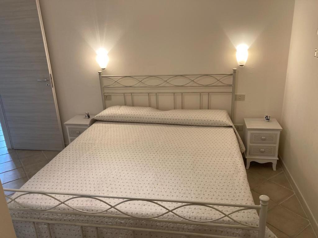 1 dormitorio con 1 cama con 2 mesitas de noche y luces en Centrale a Tropea, en Tropea