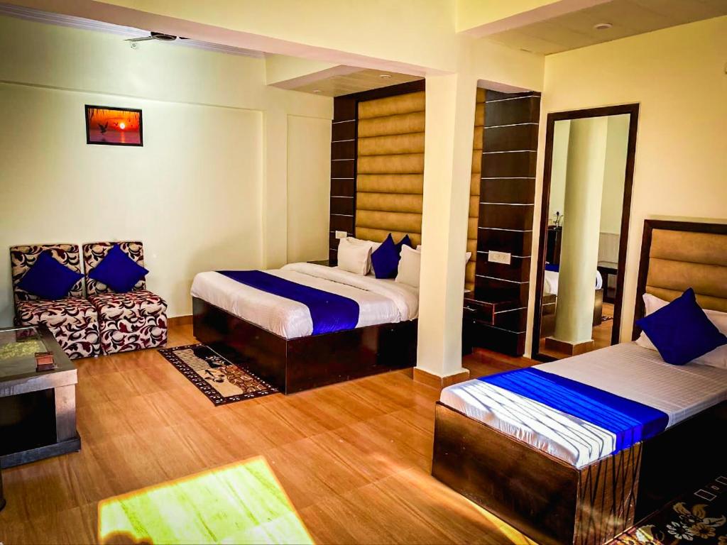 Habitación de hotel con 2 camas y espejo en Heaven Hotel, en Chamoli
