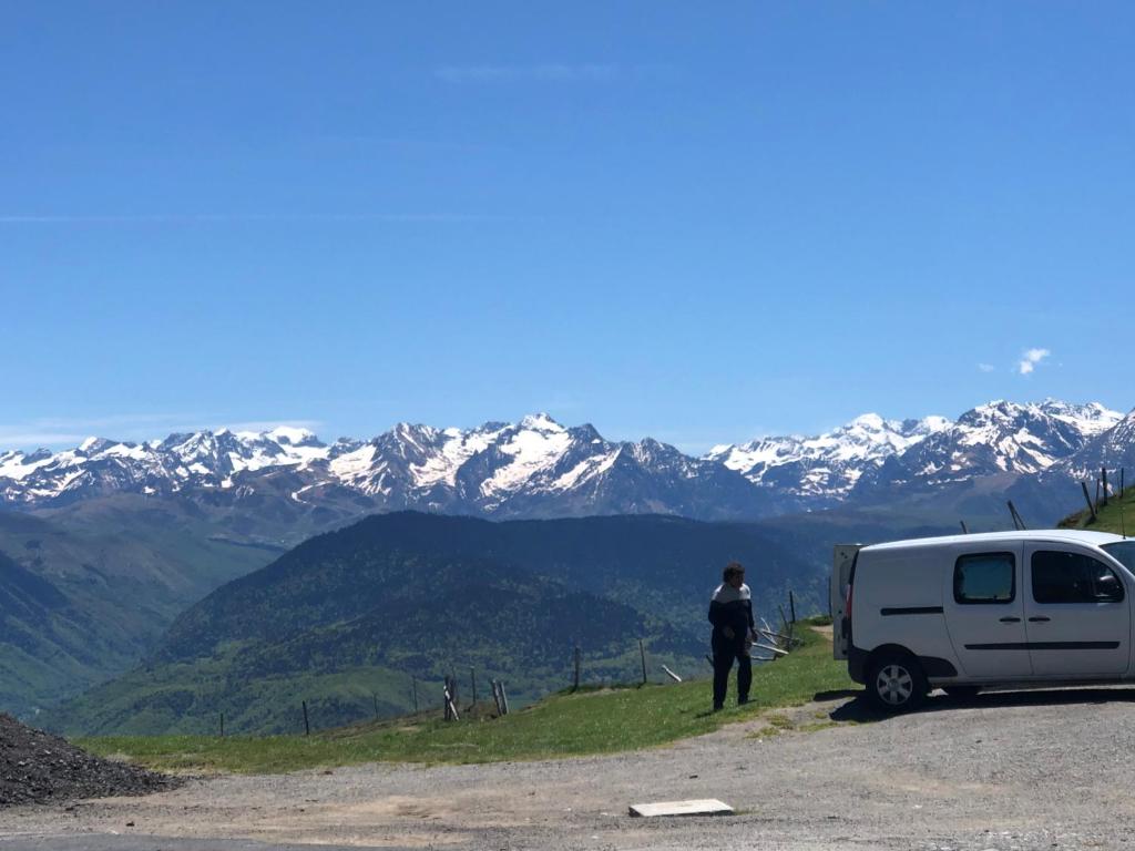 Una mujer parada junto a una furgoneta blanca en una montaña en MAISON MEDIEVALE, en Sarrancolin