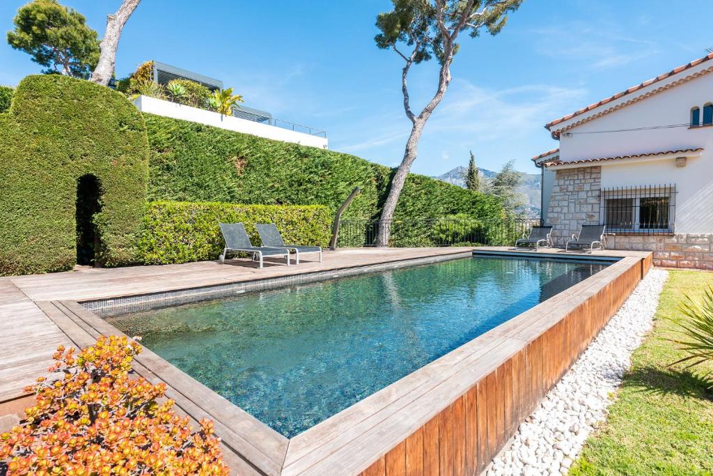 uma piscina num quintal com um deque de madeira em La Villa Roquebrune em Roquebrune-Cap-Martin