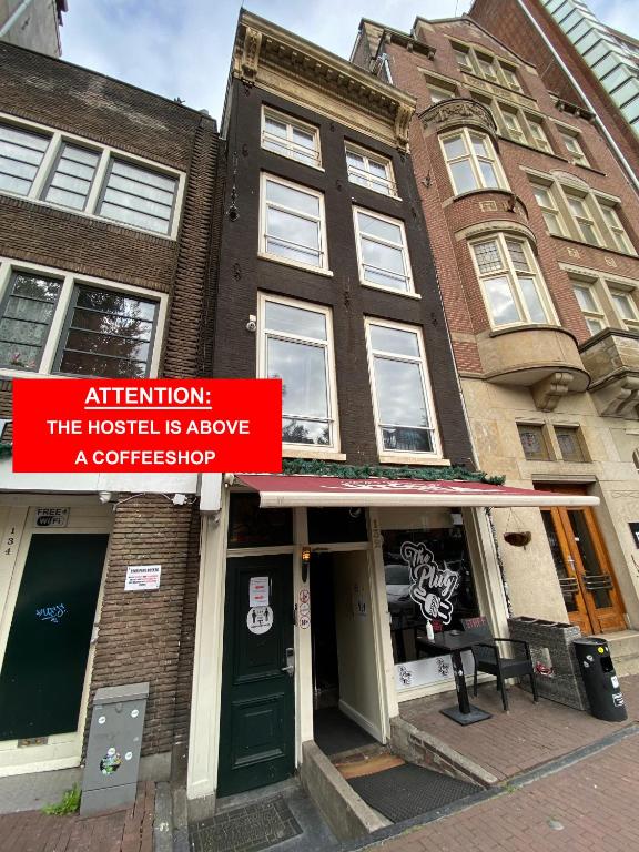 a building with a red sign in front of it at Hostel Utopia in Amsterdam