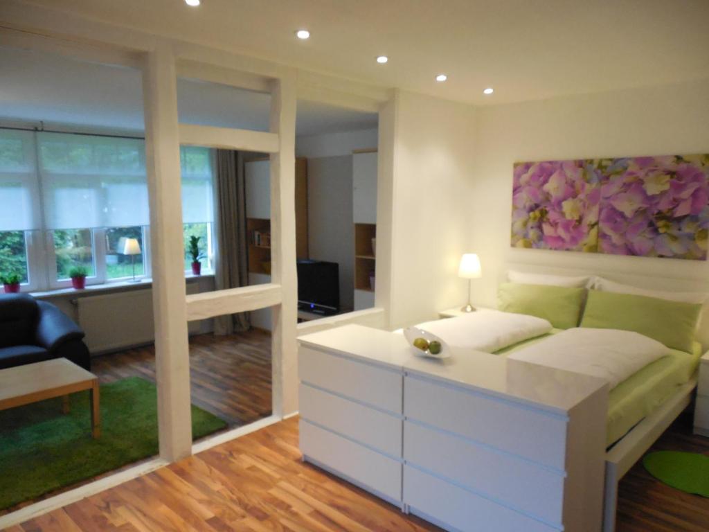ヴェルニゲローデにあるApartment Haus Brüchertのベッドルーム1室(ベッド1台付)、リビングルームが備わります。