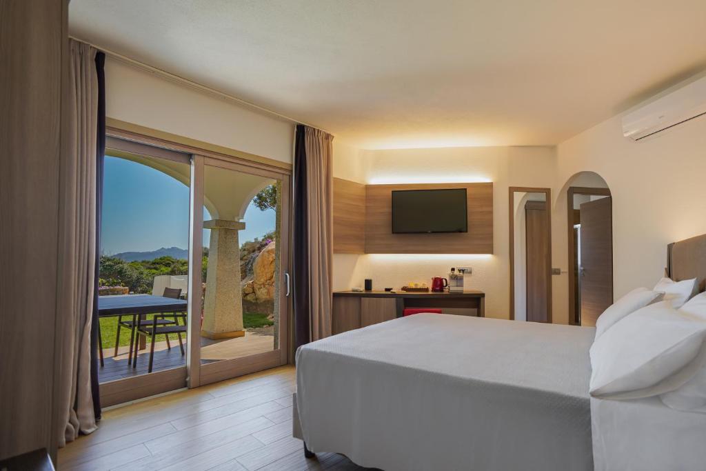 una camera con letto e un balcone con TV di Your lovely and elegant home with garden sea view a La Maddalena