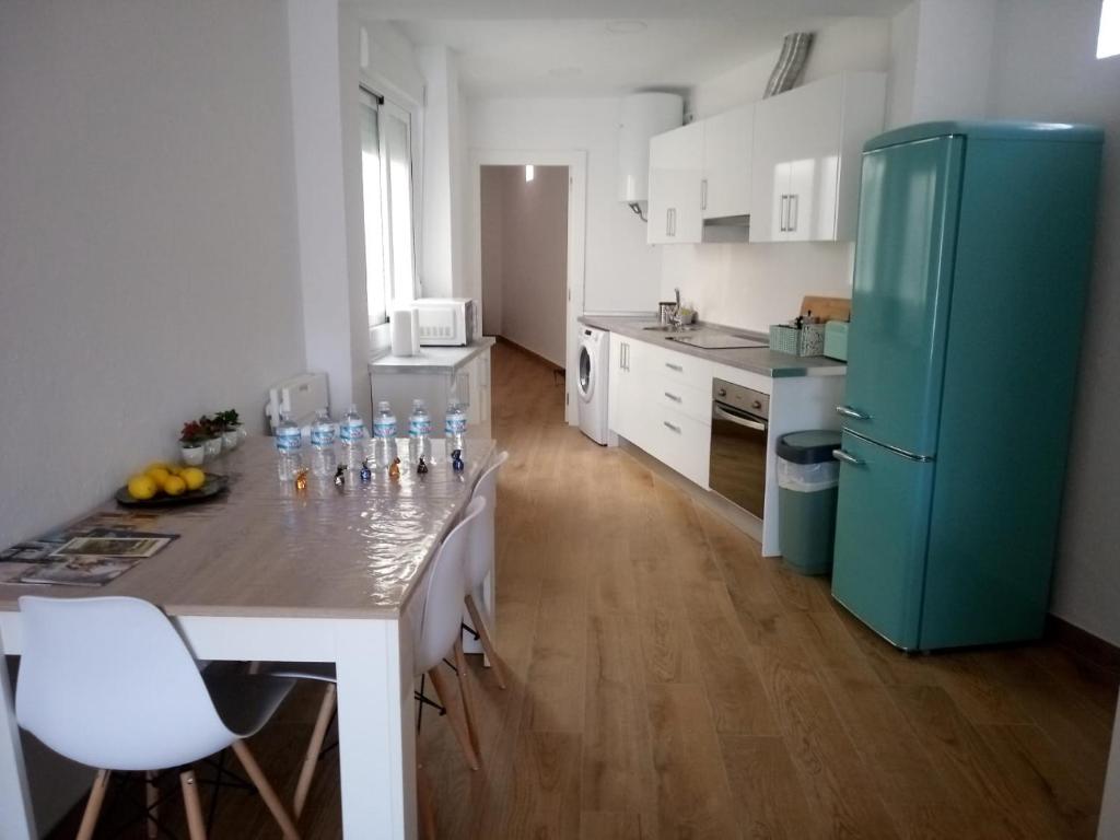 a kitchen with a refrigerator and a table with bottles on it at Apartamento Garcar in Murcia