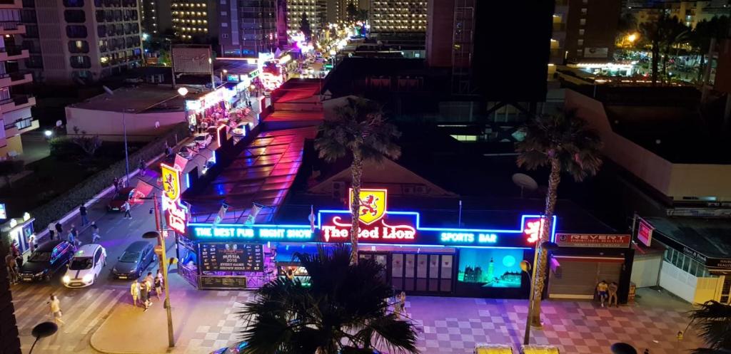 a city street at night with neon signs at Apartments Carlos V in Benidorm