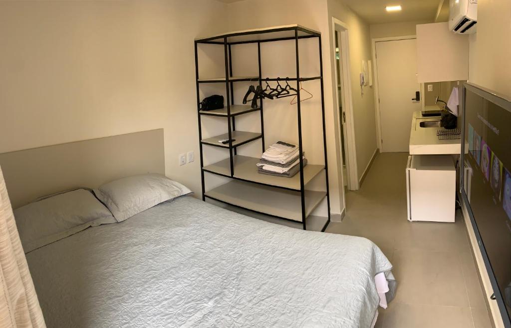 1 dormitorio con cama y estante para libros en Smartflat Vivendas do Mar, en João Pessoa