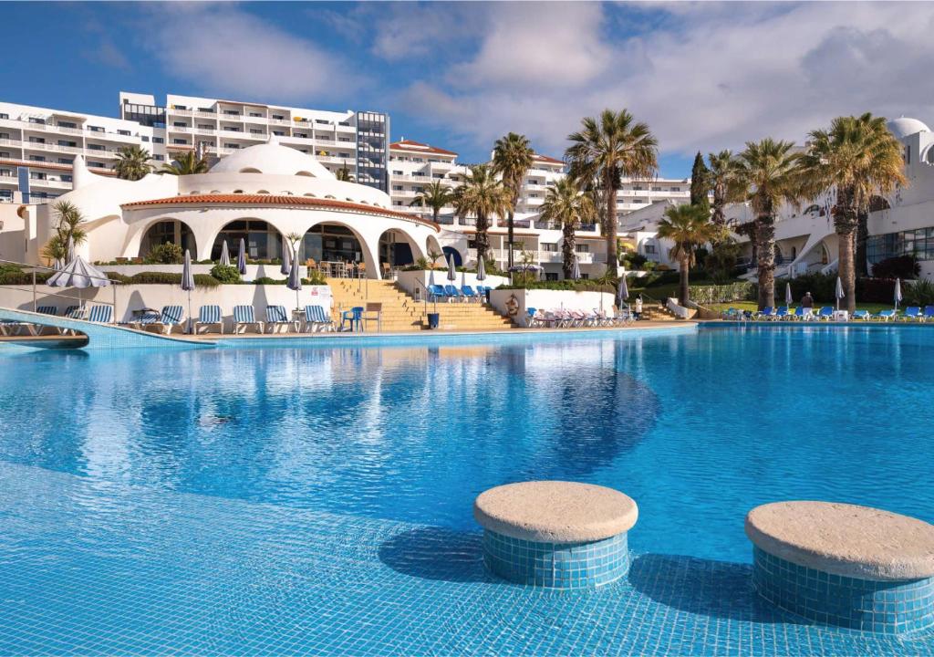 uma grande piscina em frente a um resort em Grand Muthu Oura View Beach Club em Albufeira