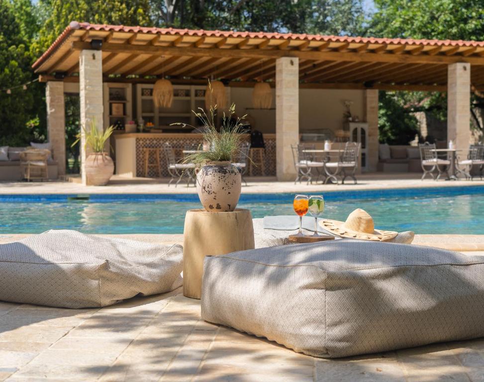 una piscina con una mesa con una bebida y un patio en Petrino Eco Village en Áfitos