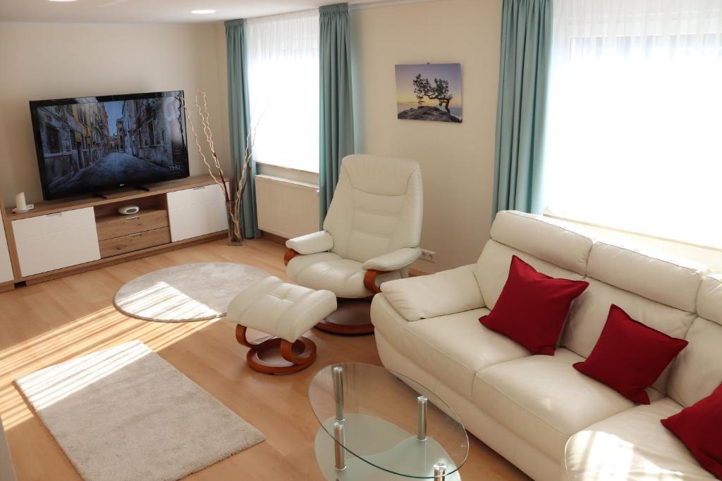 uma sala de estar com um sofá branco e uma televisão em Liebevoll renoviertes Haus mit großem Garten in Dresden em Dresden