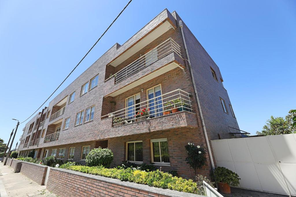 um edifício de tijolos com varandas e plantas nele em FLH Gaia Valadares Comfy Apartment em Vila Nova de Gaia