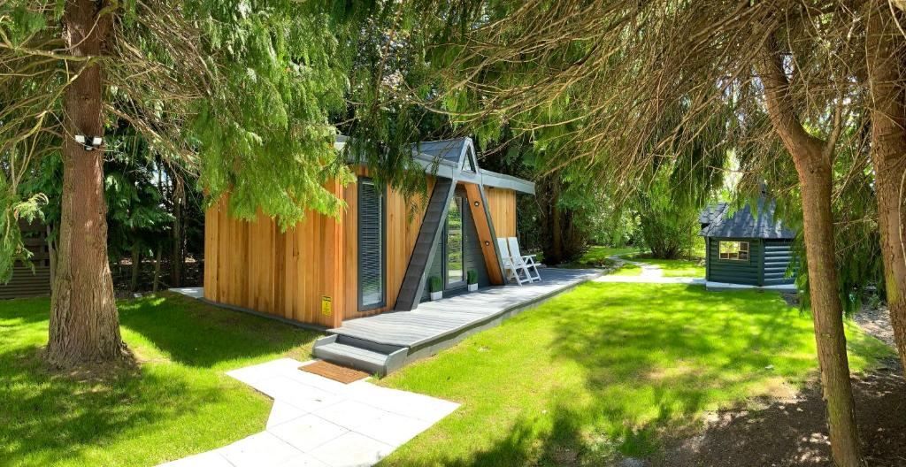 a cabin in the middle of a yard with trees at Royal Snug & Wee Snug Cabins in Kincardine OʼNeil