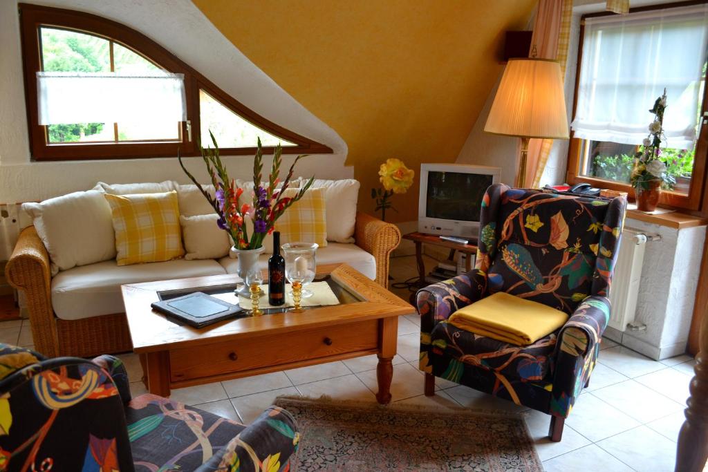 a living room with a couch and a table and chairs at Haus Bachschwalbe in Sasbachwalden