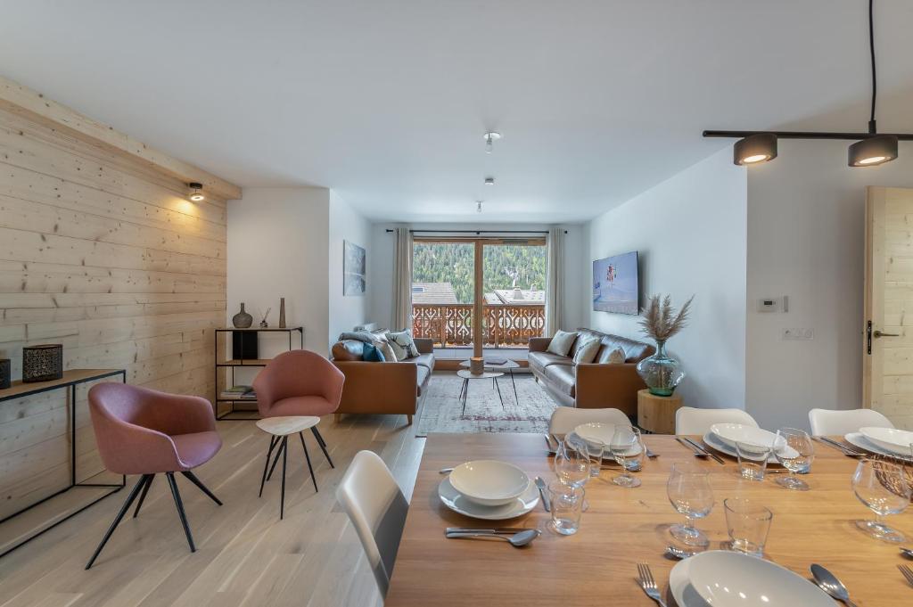 Habitación con mesa, sillas y sala de estar. en Perle de Savoie - Apt A103 - BO Immobilier, en Châtel