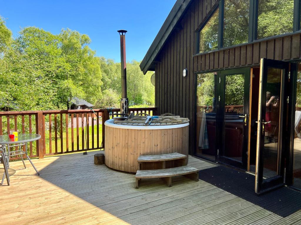 bañera de hidromasaje en la cubierta de una casa en Fern Lodge, en Dallavich