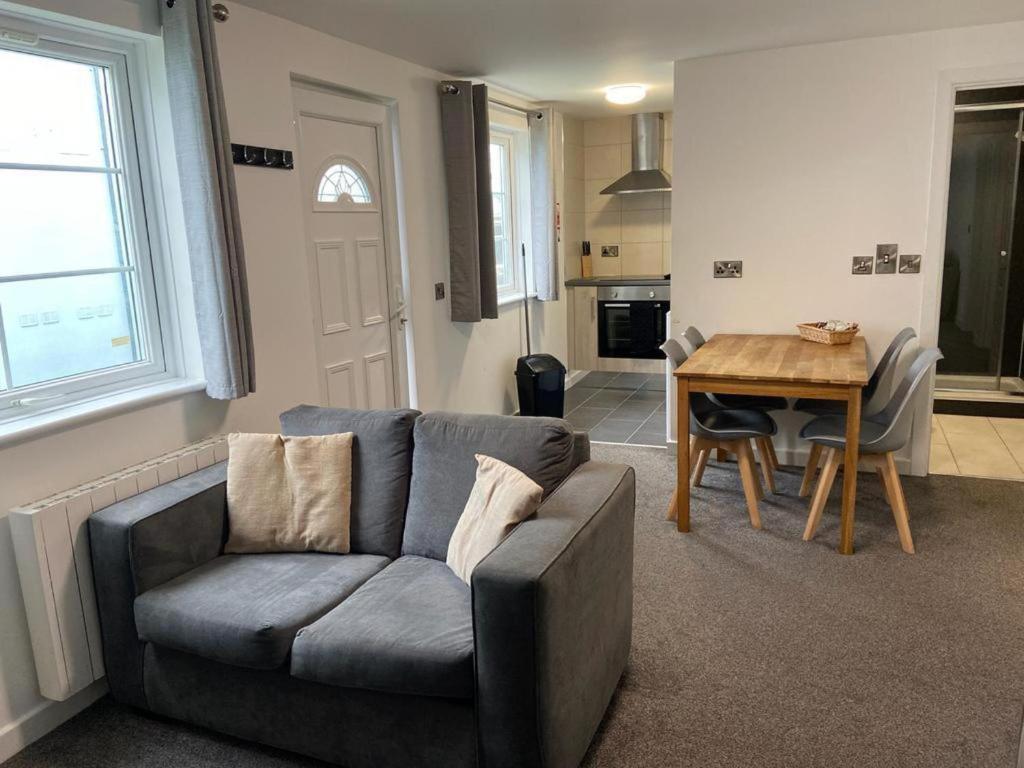 a living room with a couch and a table at Apartment with Access to Pool Spa & Soft play in Ilfracombe
