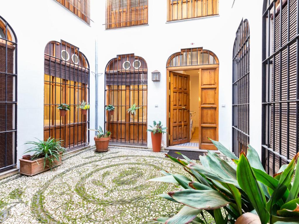 a courtyard of a house with wooden doors and plants at Apartamento Catedral in Granada