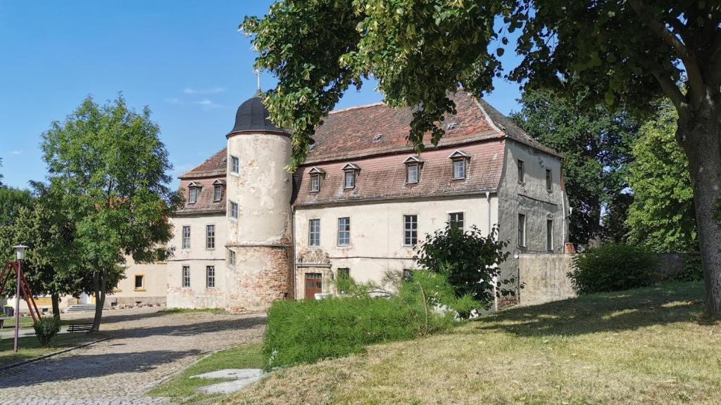 um edifício antigo com uma torre numa colina em Schloss Gröbitz em Gröbitz