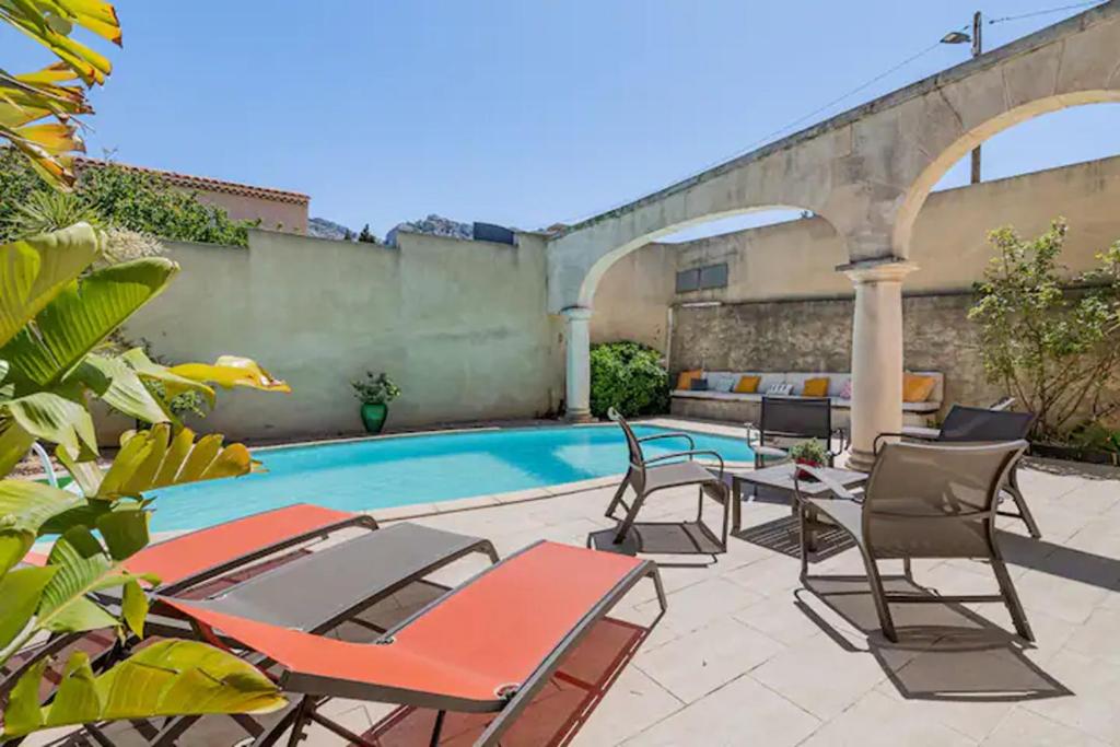 un patio avec des chaises et une piscine dans l'établissement Villa Côté Sud, à Marseille