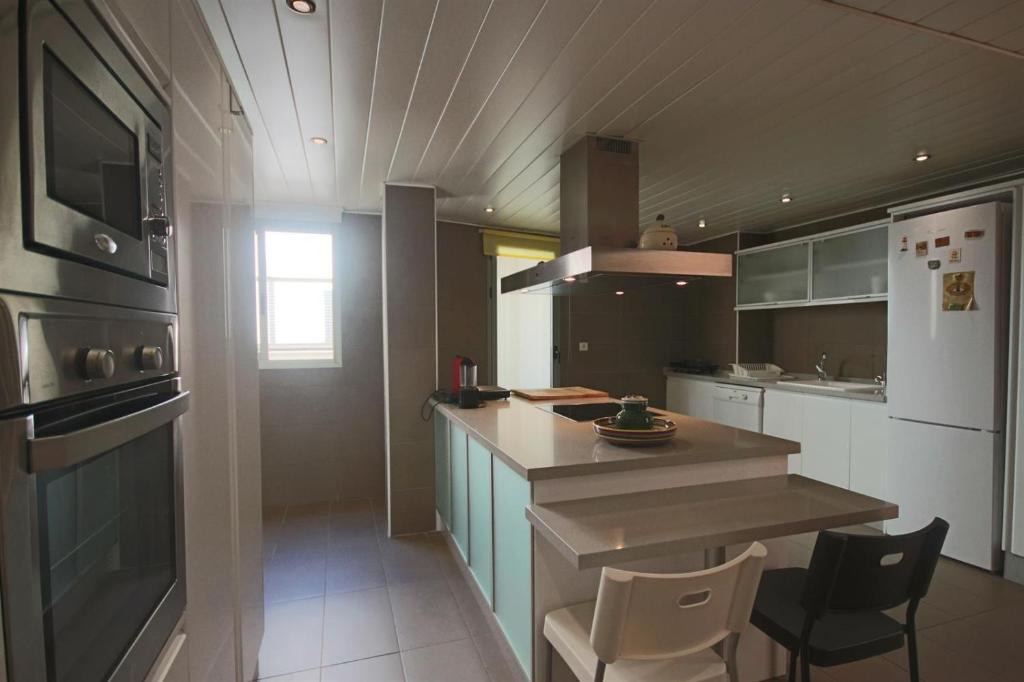 a kitchen with a counter and chairs in it at Homeincalpe Borumbot in Calpe