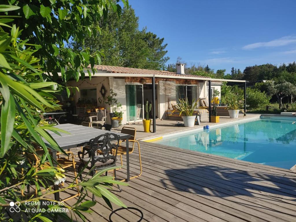 a house with a deck and a swimming pool at B&B La Terre Brûlée in Aigues-Mortes