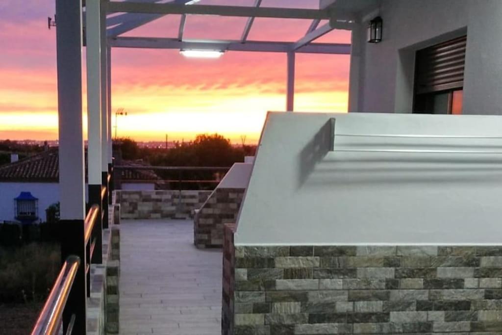 a balcony of a house with a sunset in the background at Villa la Parra in Chiclana de la Frontera