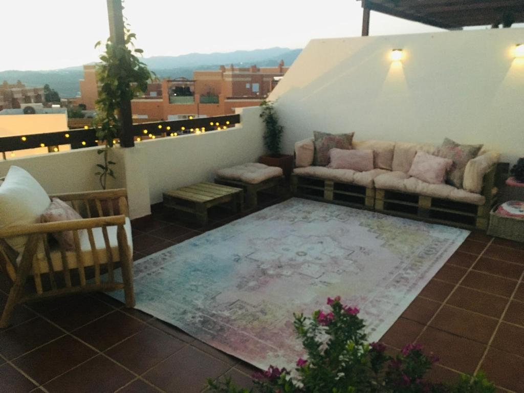 - Balcón con sofá y alfombra en Alquiler casa veraneo Málaga Valleniza, en Málaga