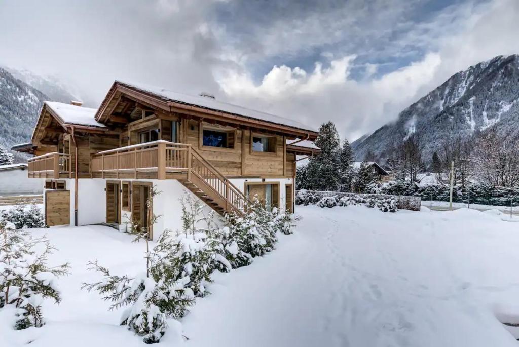 uma cabana de madeira na neve com montanhas em Amazing chalet em Chamonix-Mont-Blanc