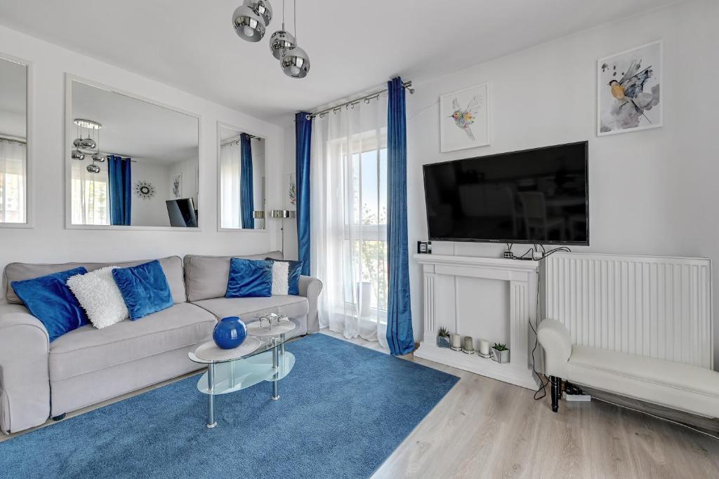 a living room with a couch and a tv at Wave Apartments - Cztery Oceany 2 in Gdańsk