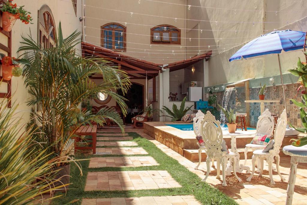 a patio with chairs and a table and a pool at POUSADA CAPIM LIMÃO in Diamantina