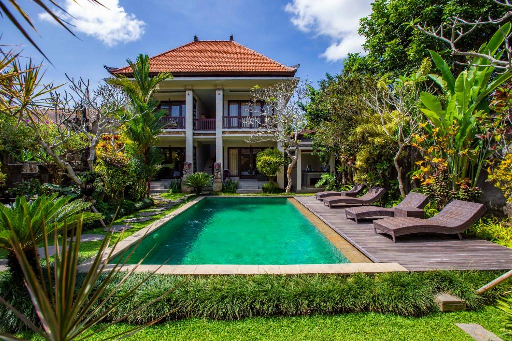 a villa with a swimming pool and a house at Lili Cottage Ubud in Ubud