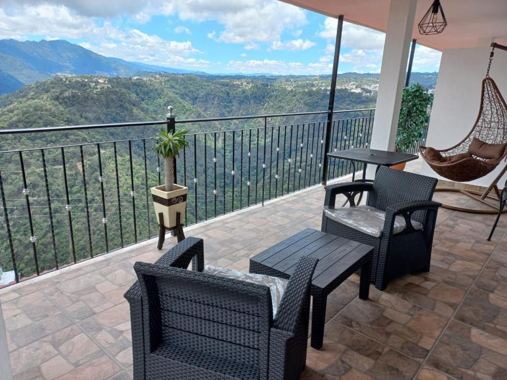 einen Balkon mit Stühlen, einem Tisch und Aussicht in der Unterkunft Hotel Vista Markés in Zacatlán