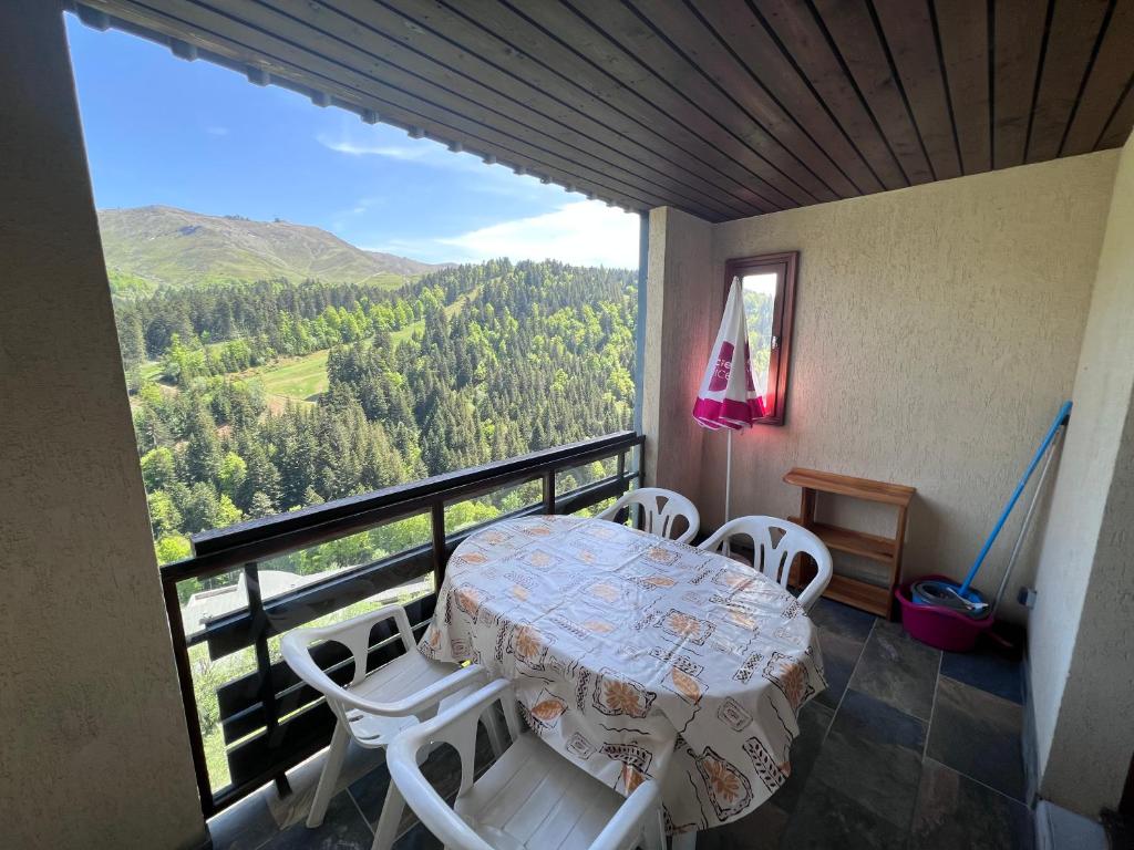 une table et des chaises sur un balcon avec vue dans l'établissement Résidence les Cristallines, à Le Lioran