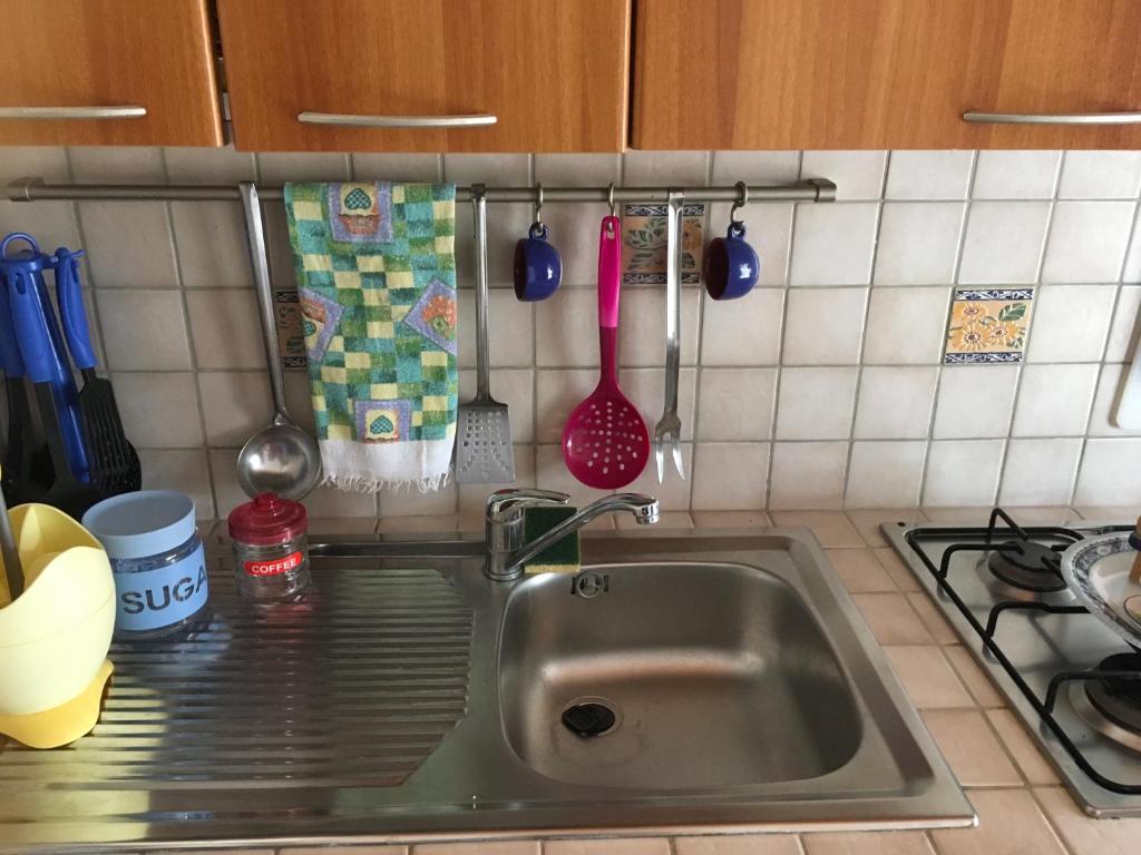 a kitchen counter with a sink and a stove at A due passi da Cala Pisana in Lampedusa